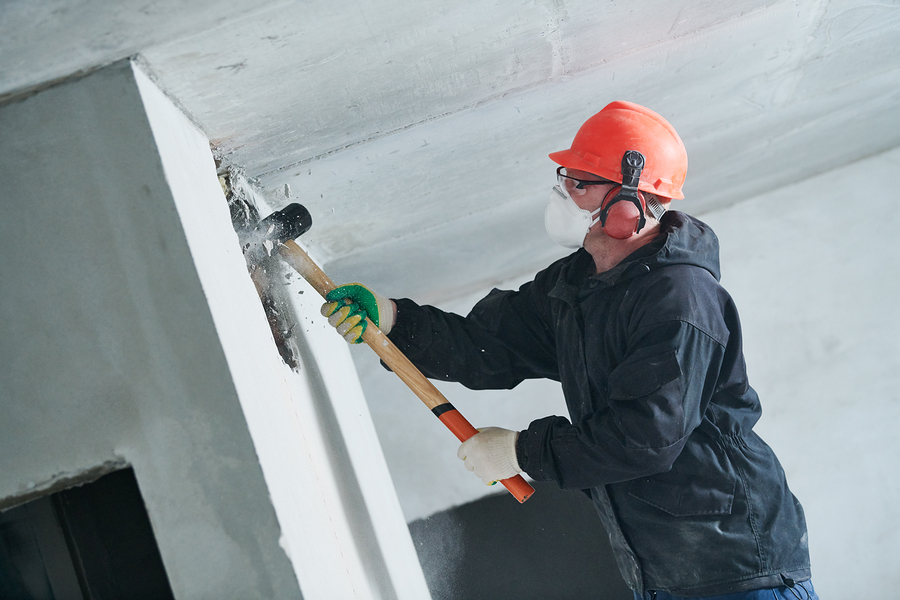 demolition work and rearrangement. worker with sledgehammer destroying wall