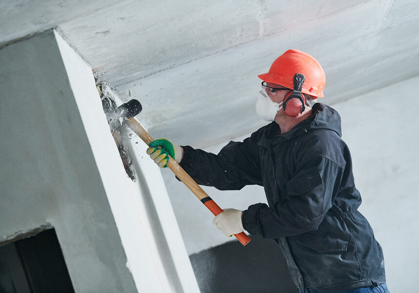 demolition work and rearrangement. worker with sledgehammer dest demolition work and rearrangement. worker with sledgehammer destroying wall